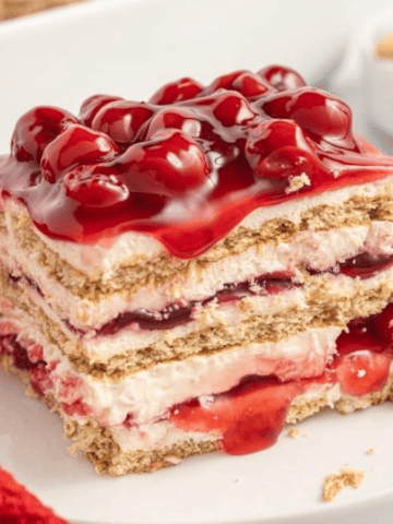 A slice of cherry cheesecake icebox cake on a plate.