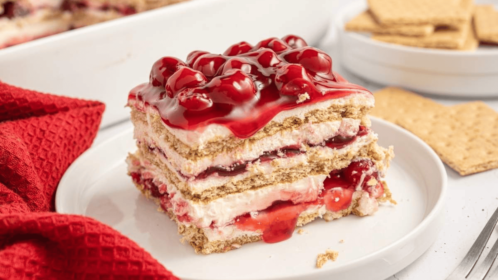 A slice of cherry cheesecake icebox cake on a plate.