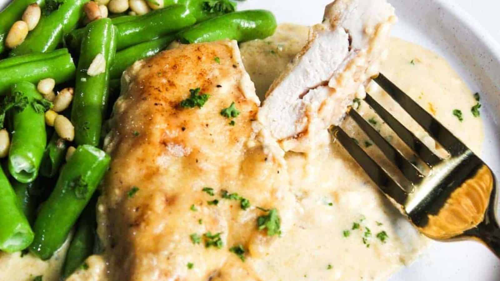 A plate with chicken and green beans on it.