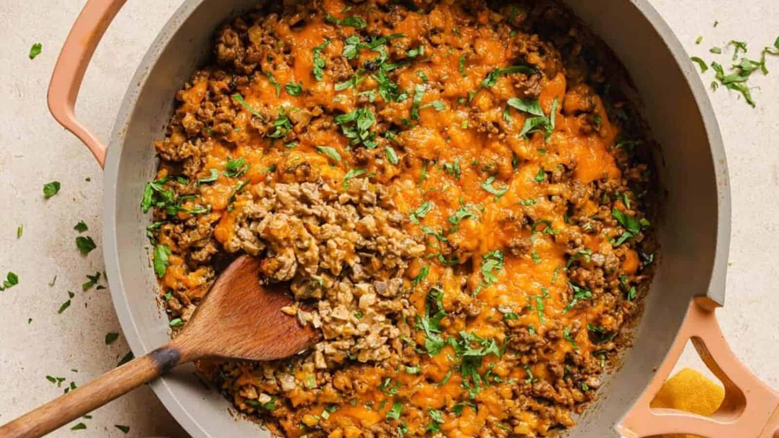 Creamy ground beef skillet with cauliflower rice with a wooden spoon.