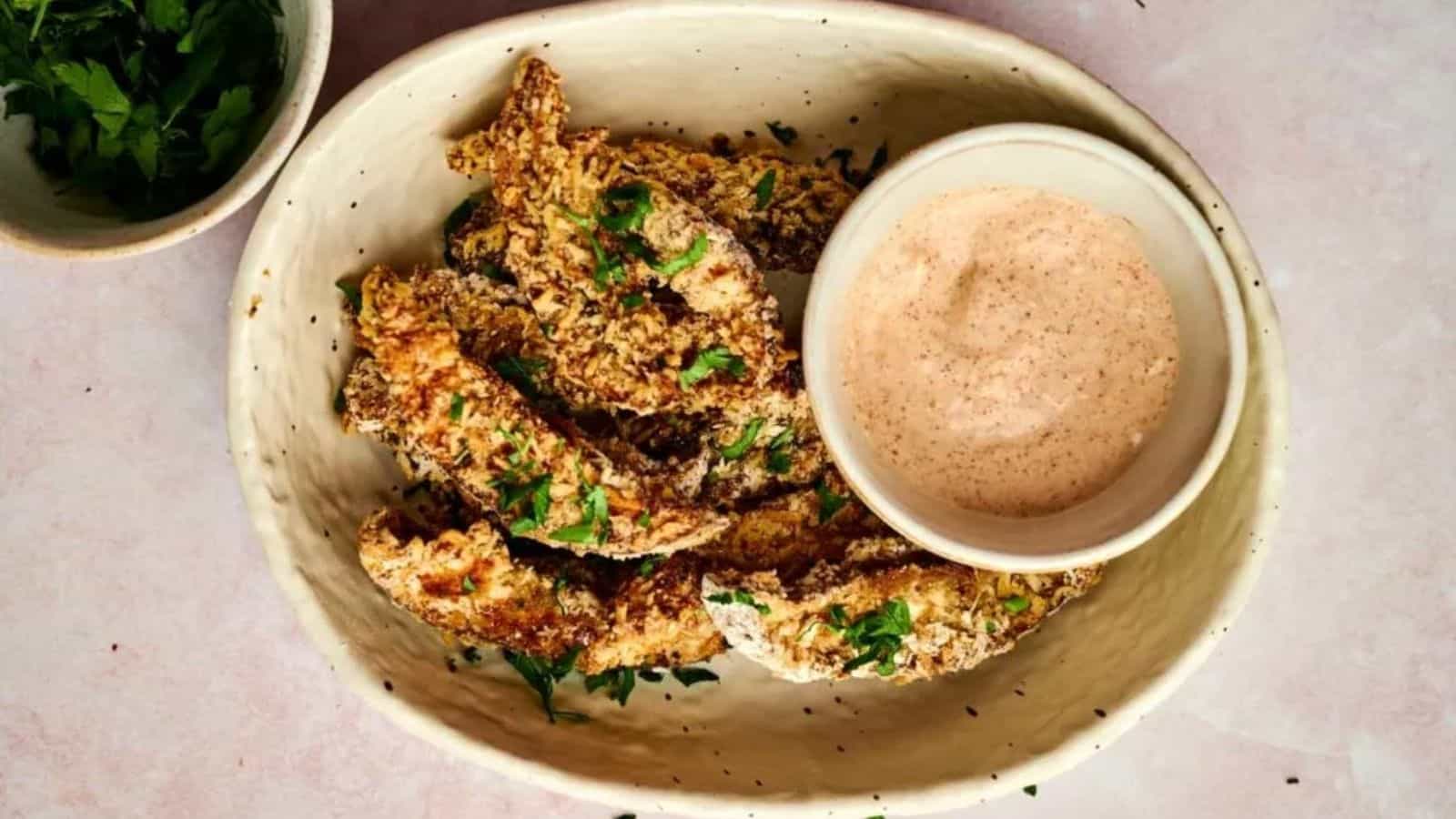 Overhead image of crispy portobello mushroom fries with a dip in a plate.