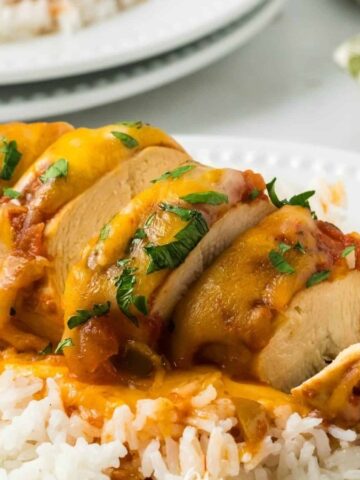 Crockpot Cheesy Salsa Chicken on a plate with rice and sauce.