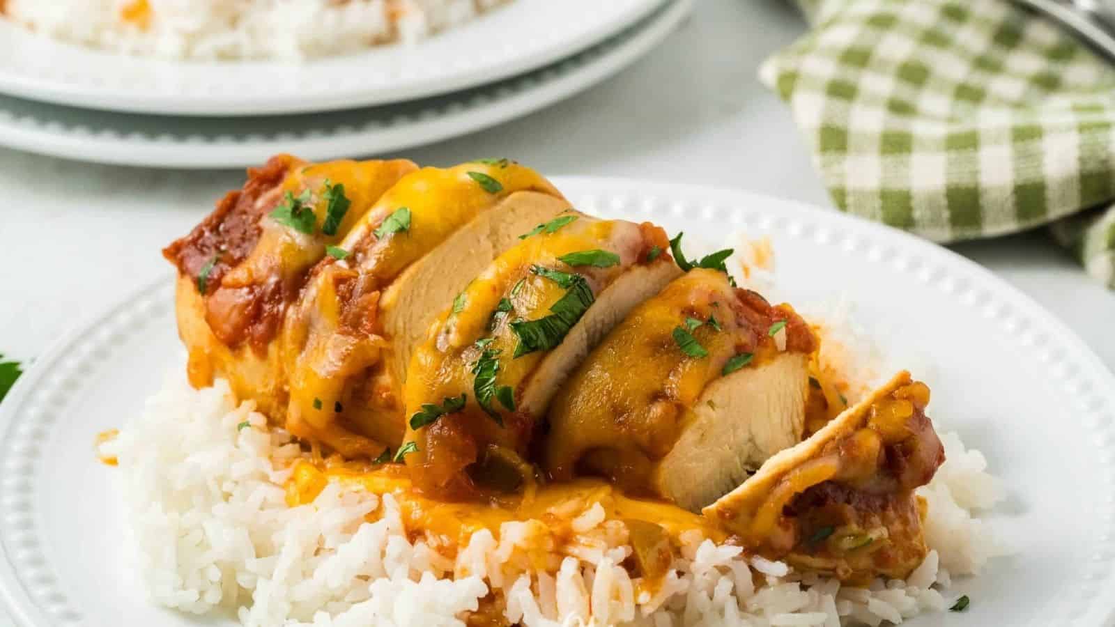 Crockpot Cheesy Salsa Chicken on a plate with rice and sauce.