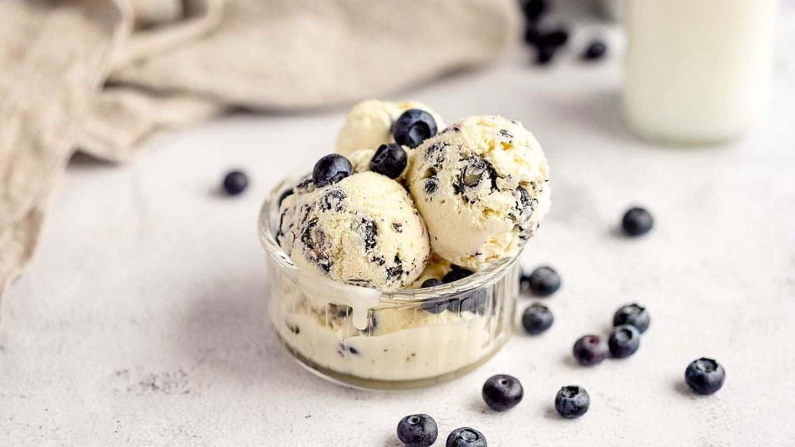 Scoops of delicious blueberry cheesecake ice cream with fresh blueberries.