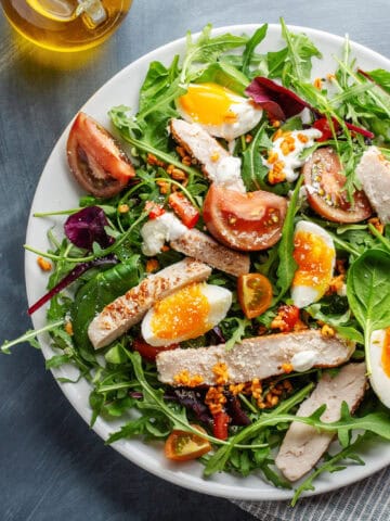 Appetizing salad with turkey, eggs, bulgur, and vegetables served on a plate.