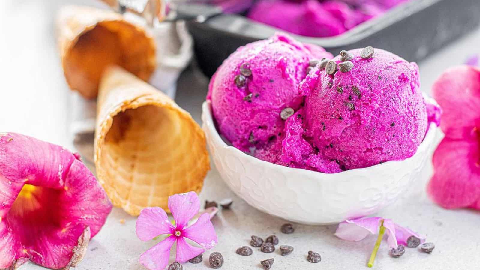 A bowl of dragon fruit ice cream with some cones.