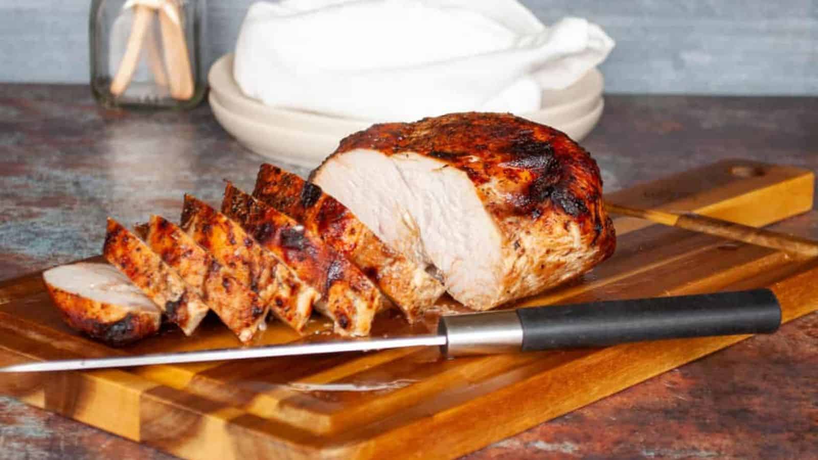 An image of an air fryer turkey breast on a wooden board.