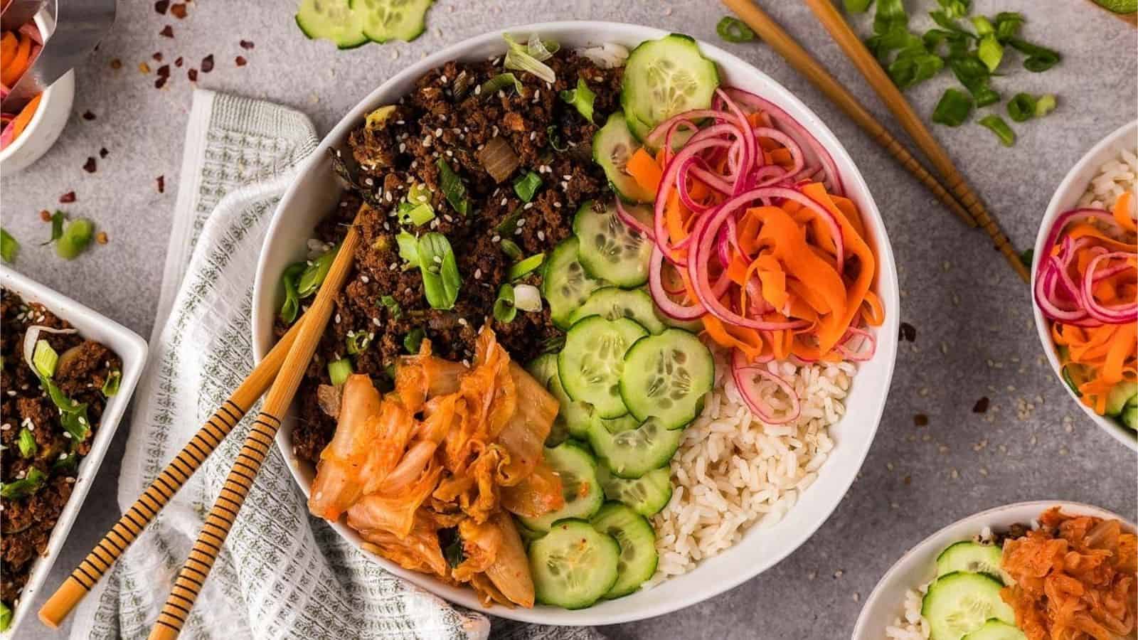 Top view of beef bulgogi with various vegetables and rice in a bowl.