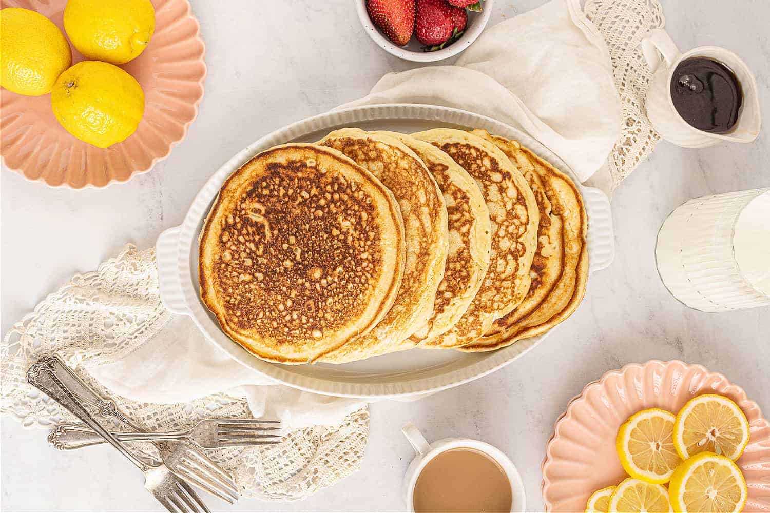 Fluffiest homemade buttermilk pancakes on a plate with syrup.