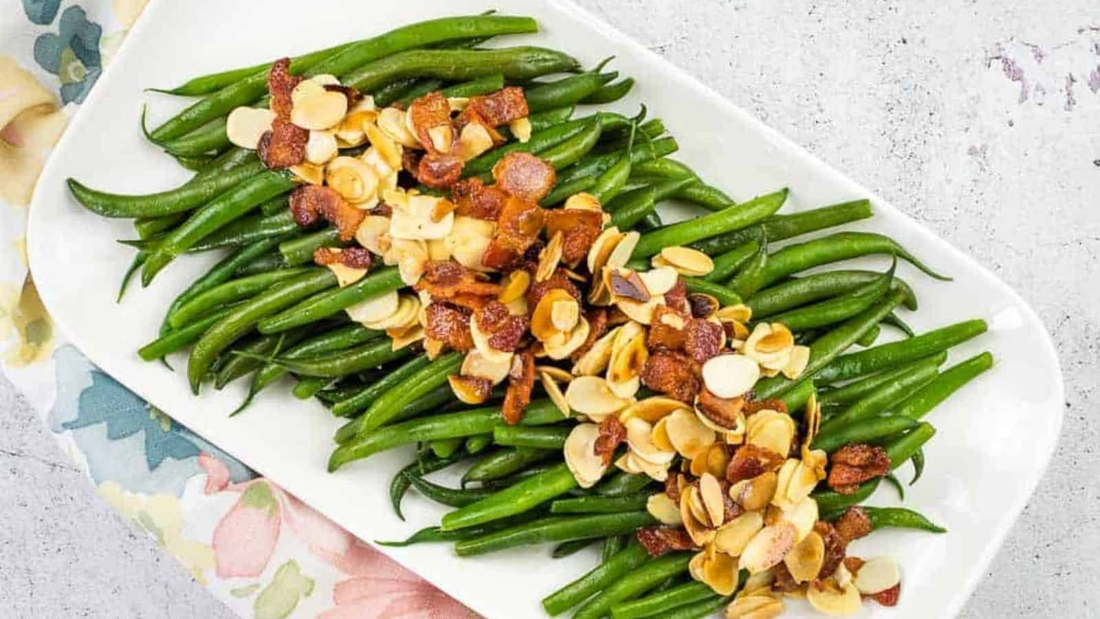 Green beans with almonds on a white plate.