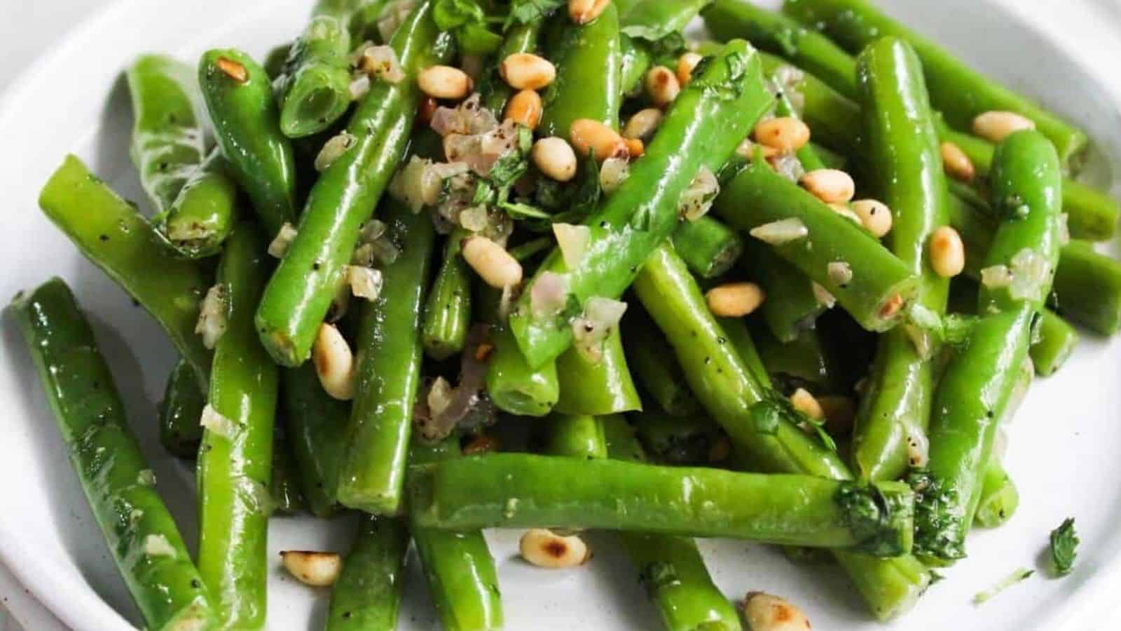 Green beans with pine nuts on a plate.