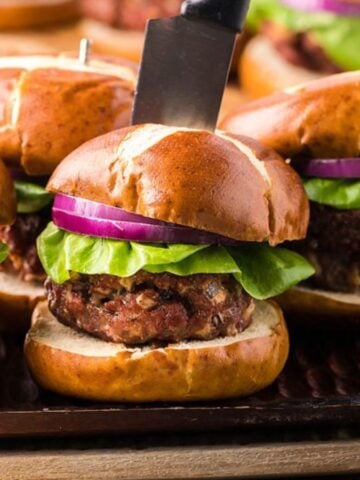 Four grilled gorgonzola buffalo burgers in a pretzel bun.