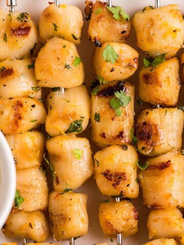 A close-up of grilled scallop skewers.