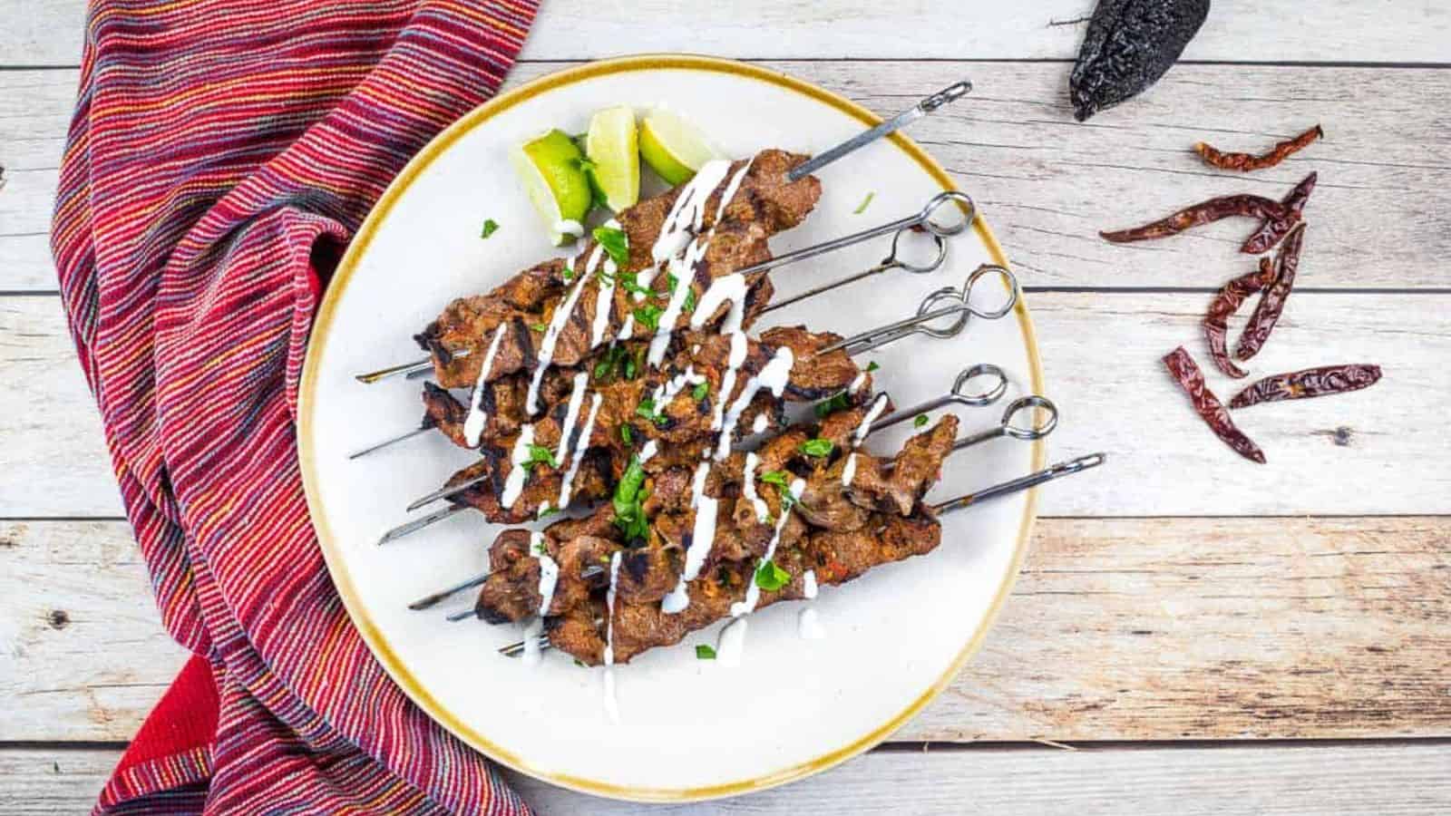 A plate of grilled steak skewers with mojo rojo.