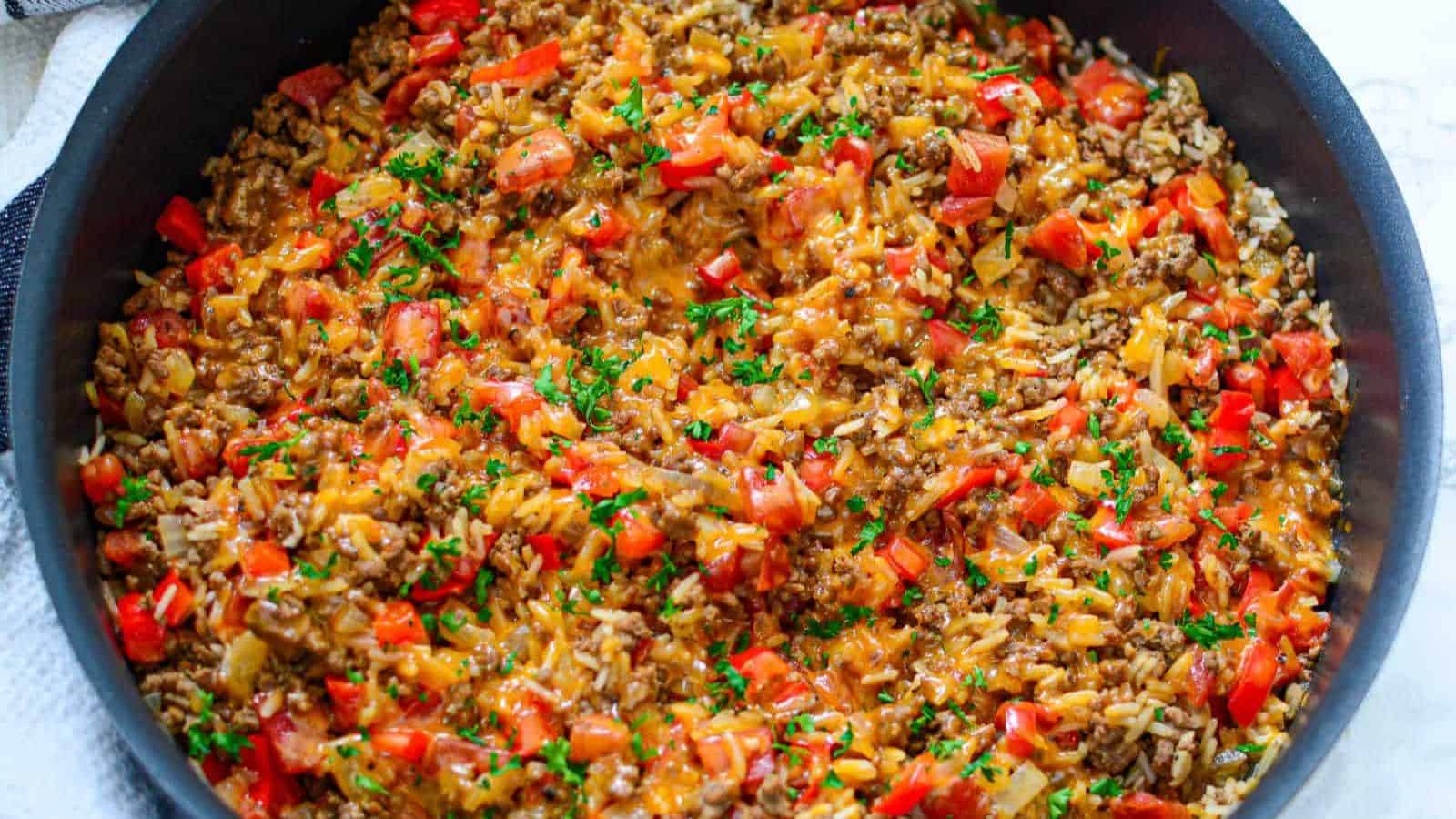 A skillet filled with beef, rice and vegetables.