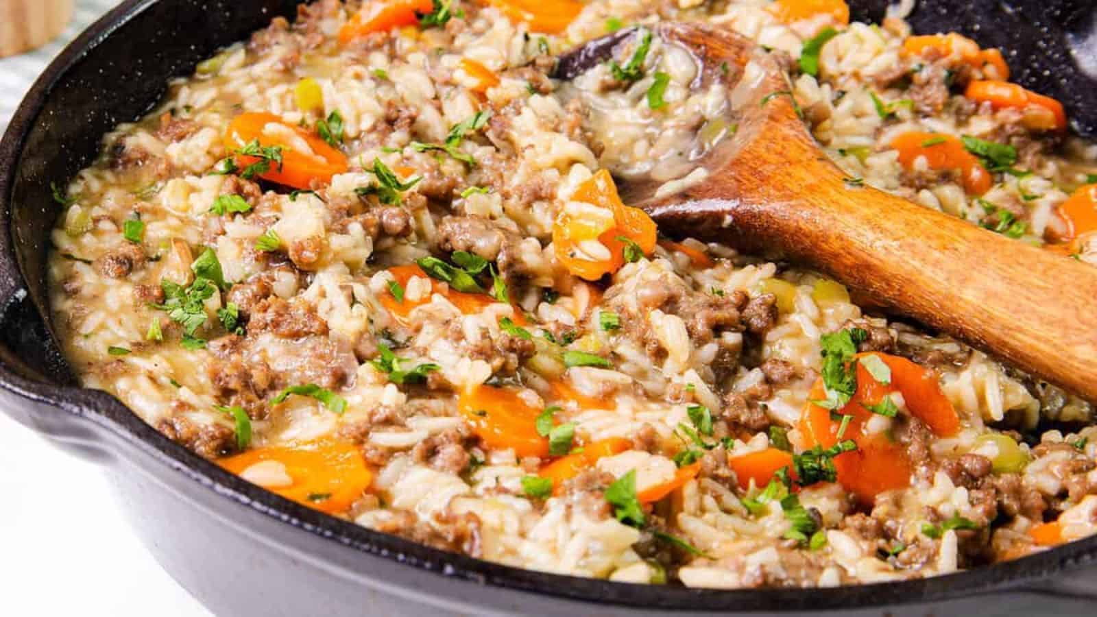 A skillet with hamburger and rice garnished with parsley, close-up.