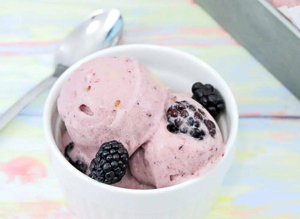 Blackberry banana nice cream in a lined dish with blackberries on top.