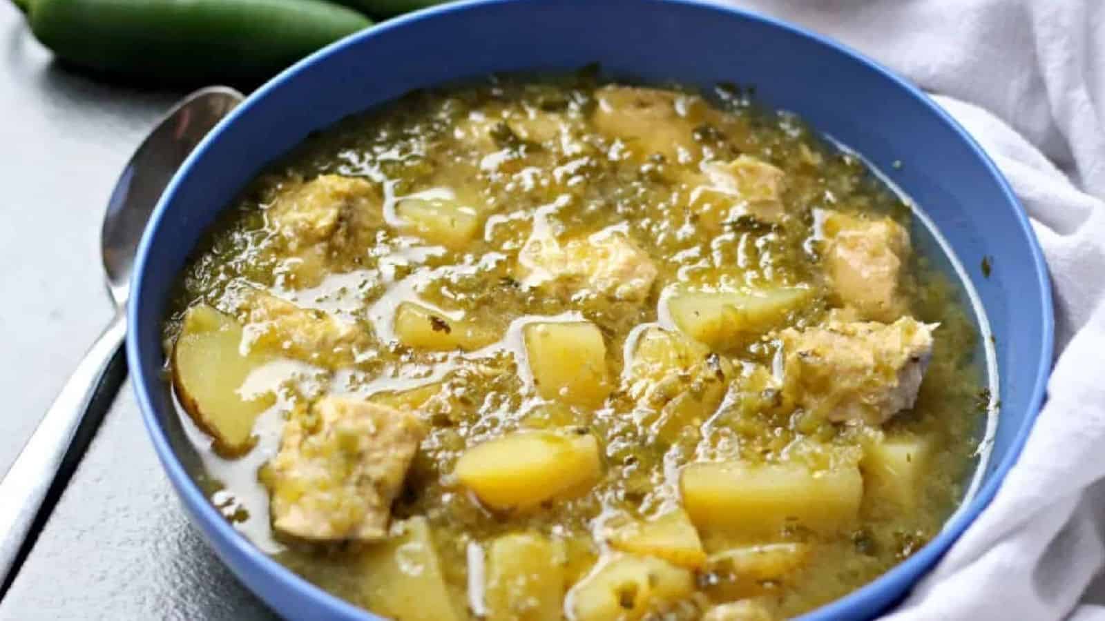 Chicken Verde with Potatoes Soup in a blue bowl with spoon.