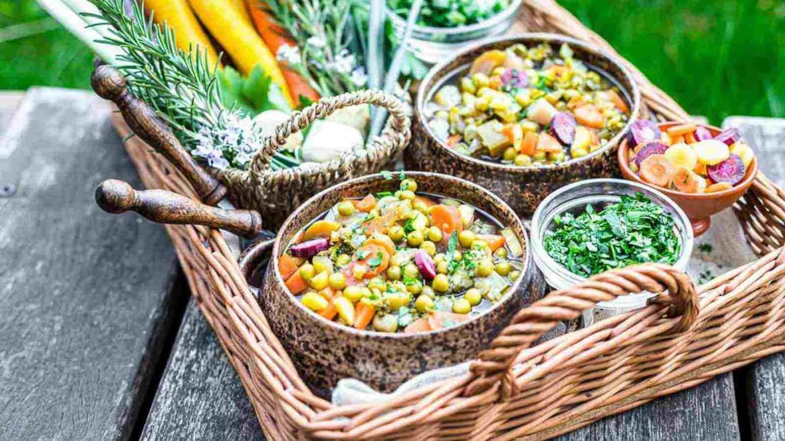 A wicker basket full of food on a wooden table.