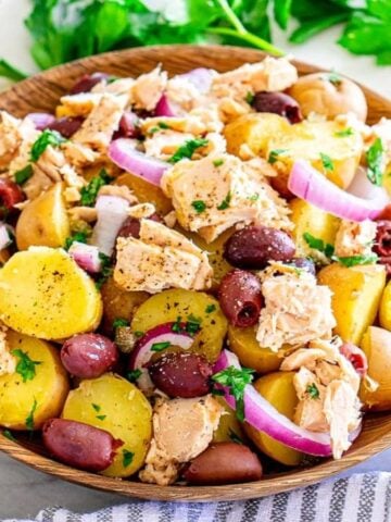 Italian Tuna Potato Salad in a wooden plate.
