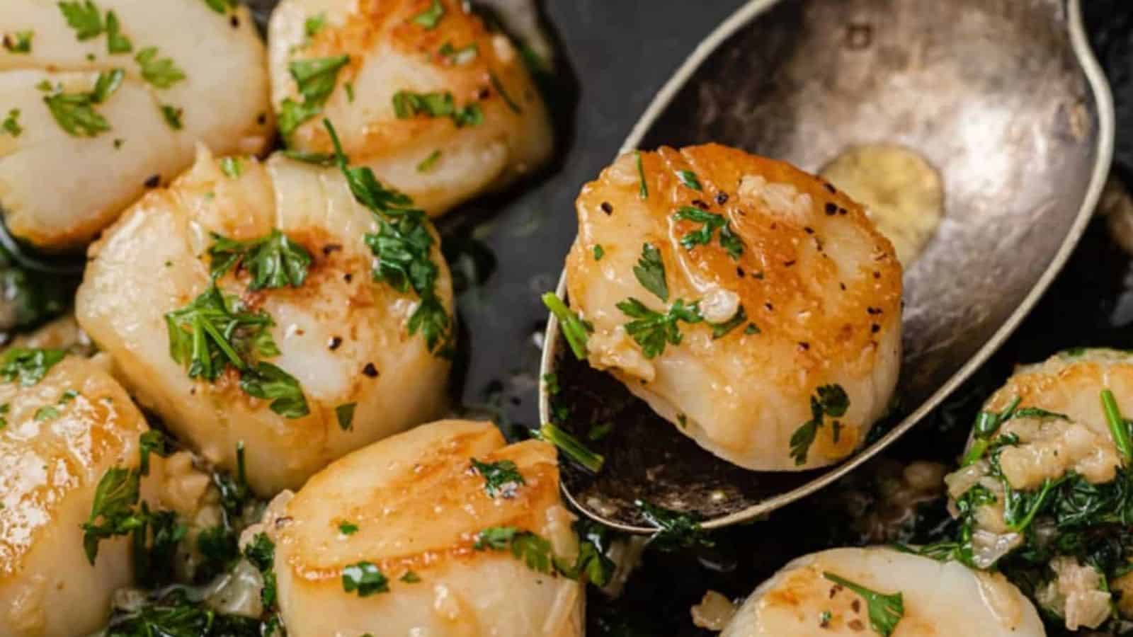 Scallops with parsley and garlic in a skillet.