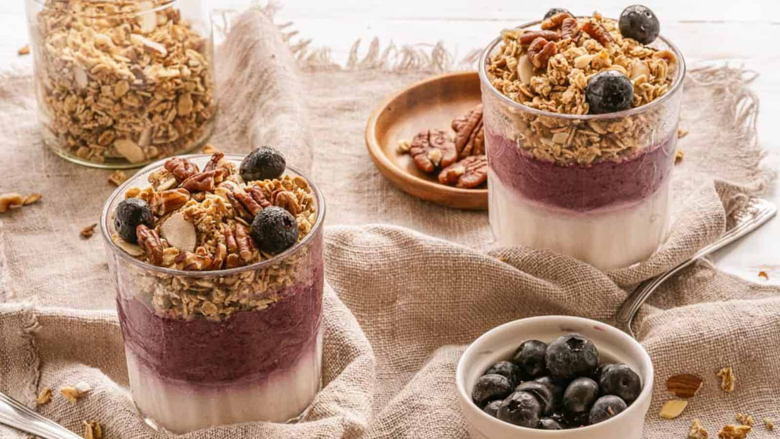 Glasses of granola with blueberries and pecans.