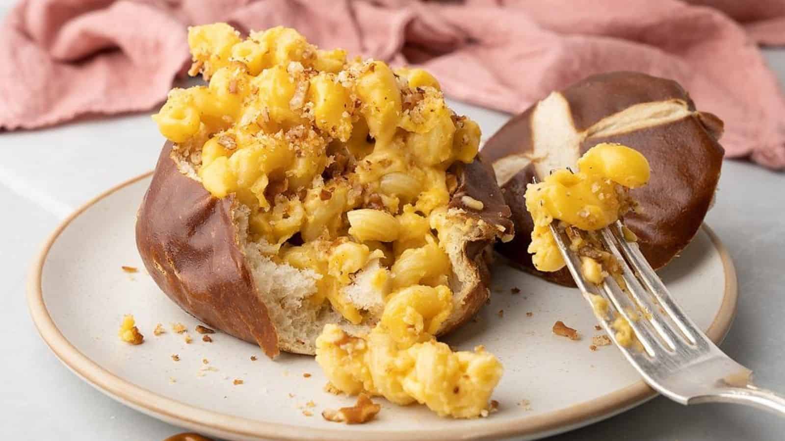 Mac beer chese in a mini pretzel bowl with a fork in a plate.