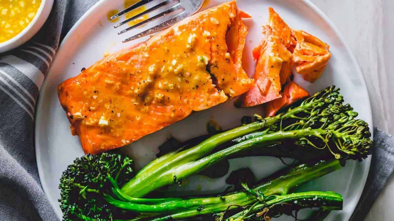 Maple mustard air fryer frozen salmon filet with broccolini on a plate.