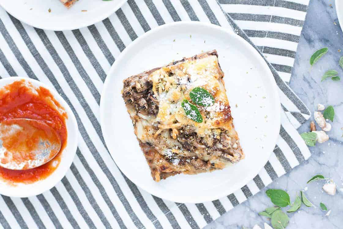 A pizza with meat and sauce on a plate.