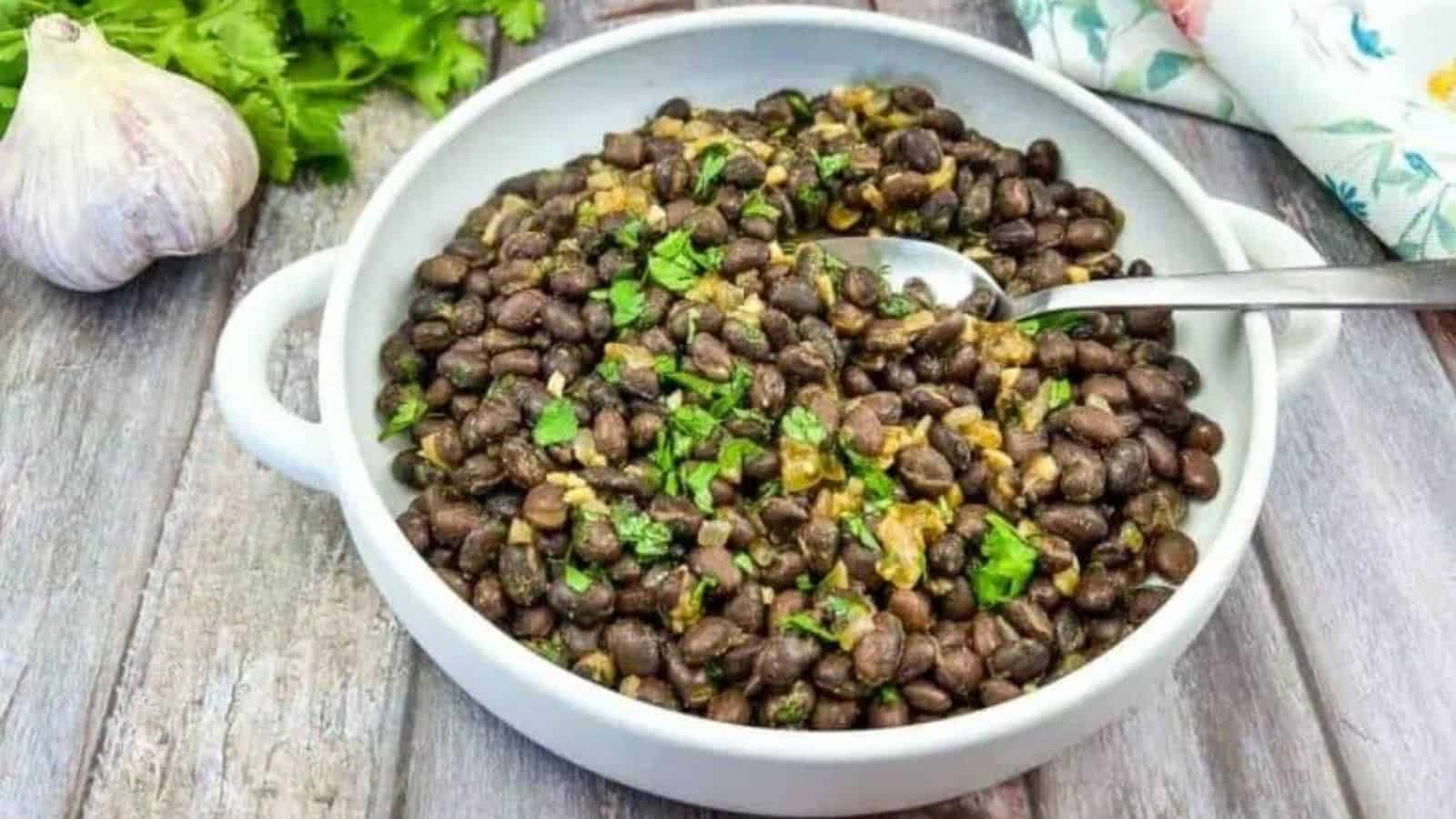 Close-up image of mexican black beans with a spoon in a plate.