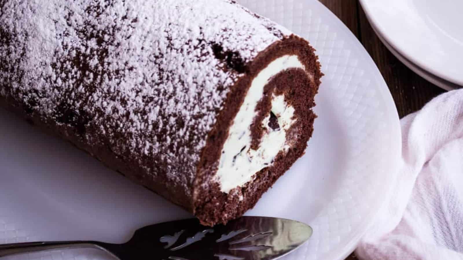 Mint chocolate chip ice cream cake roll on a plate.