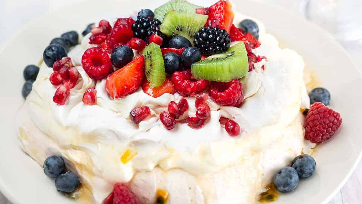 Pavlova with strawberries, blueberries, raspberries and passionfruit.