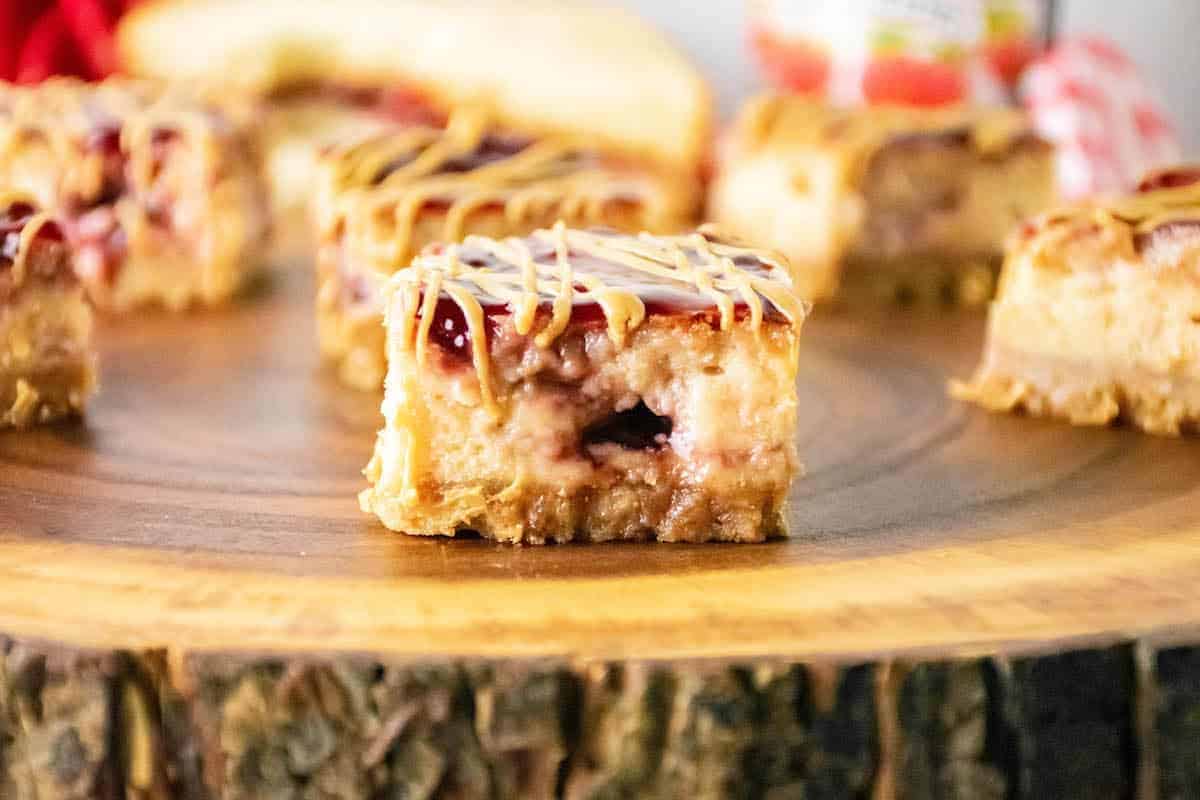 Easy peanut butter and jelly bars on a wooden cutting board.