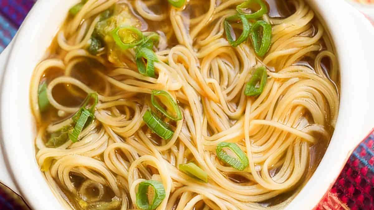 Chinese Noodle Soup in a bowl with sliced green onions on top.