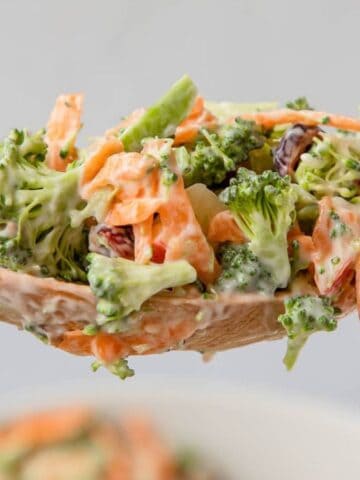 Broccoli and shredded carrots on a mixing spoon.
