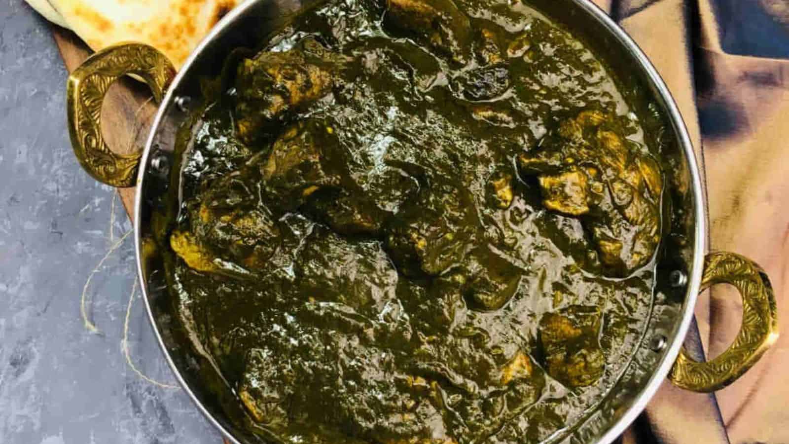 Saag Gosht served in a round, rustic bowl that highlights its rich, earthy tones.