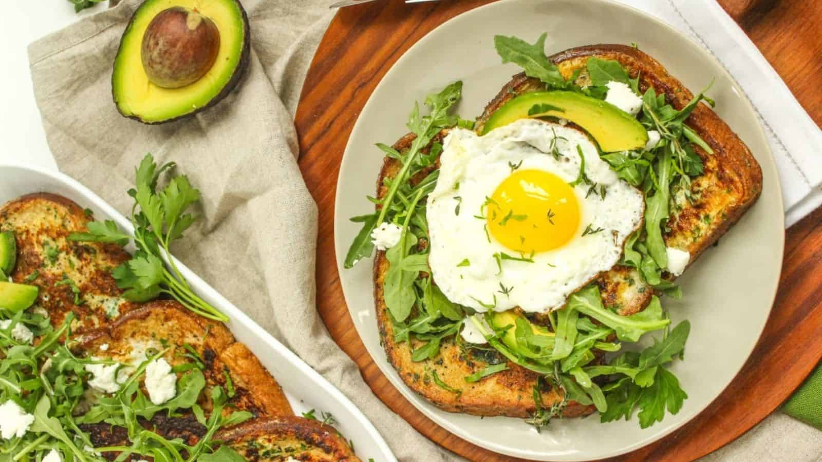 A plate of Savory French Toast with Herbs and Avocado with an egg on top.