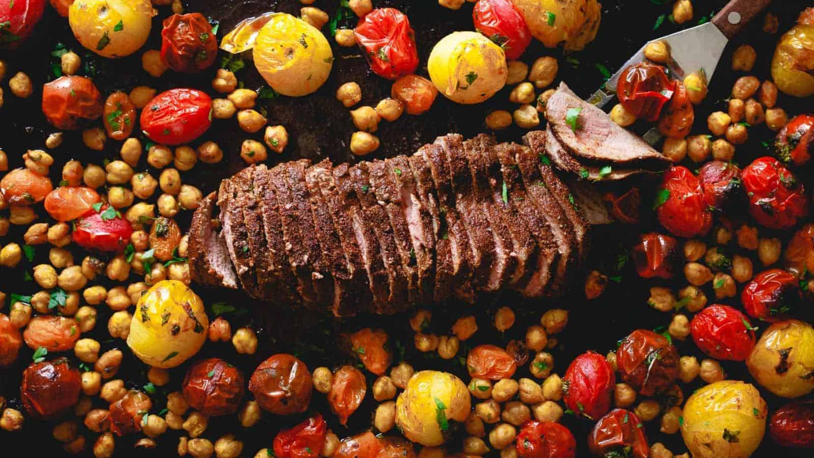 A photo of a sheet pan Mediterranean roast lamb with chickpeas and cherry tomatoes.