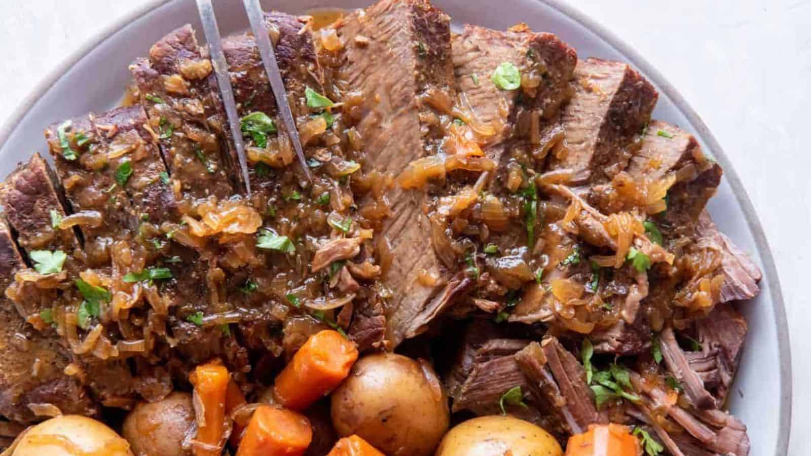 A plate of slow cooker London broil with a side of veggies.