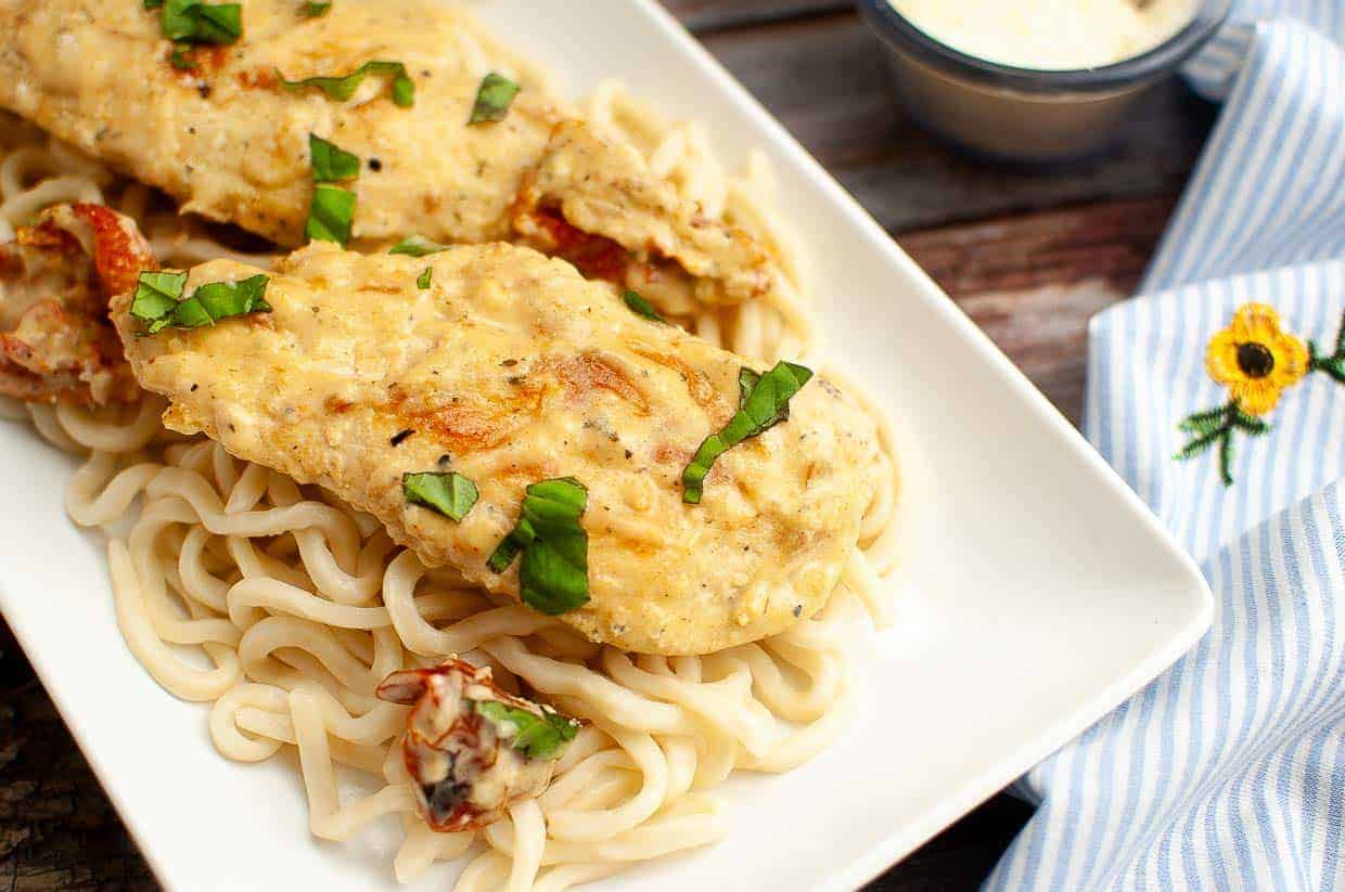 A plate of marry me chicken over pasta.