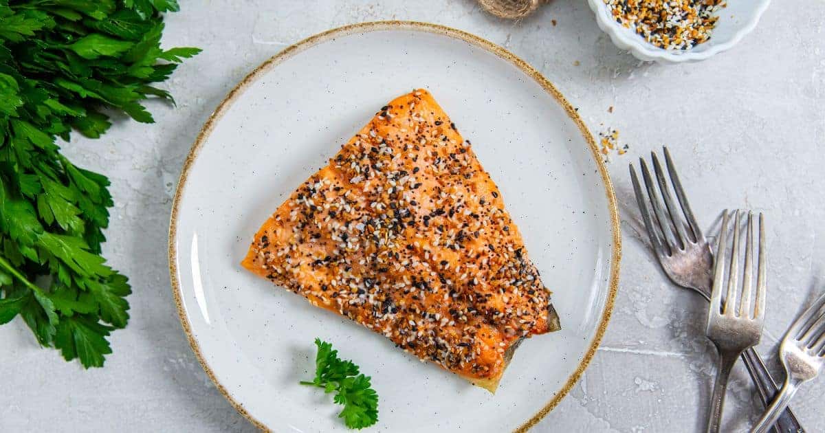 Air Fryer Everything Bagel Salmon with parsley on a white plate.