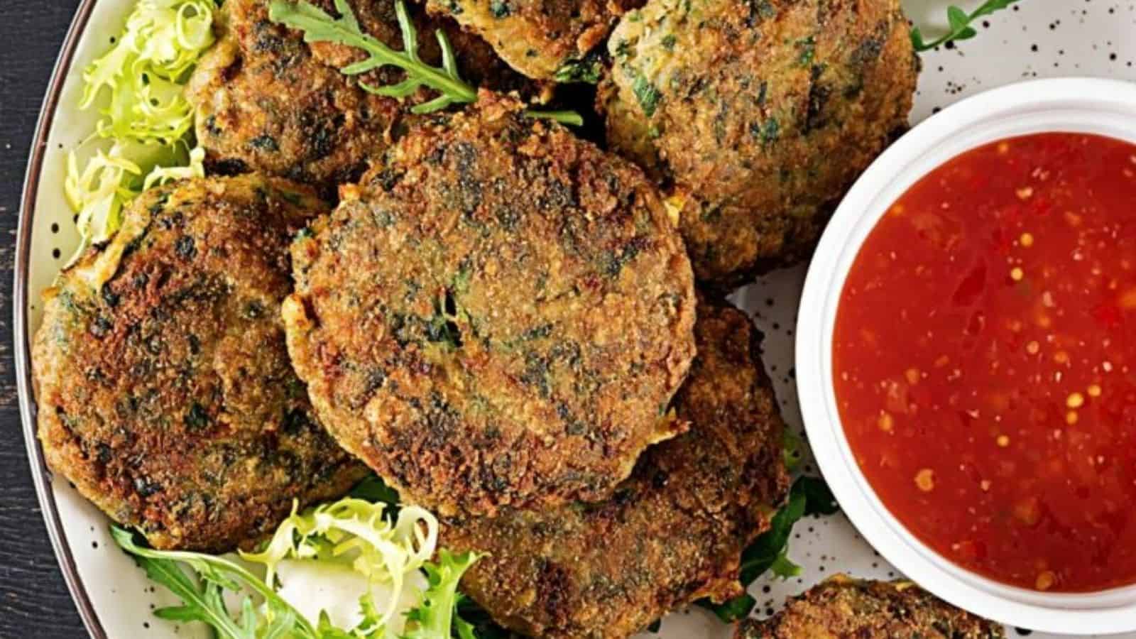 Overhead image of spinach salmn burgers with a dip in a plate.