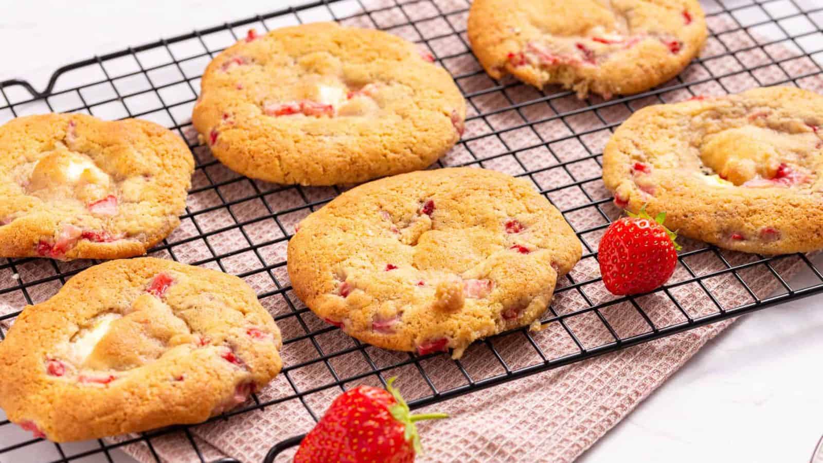 An image of strawberry cheesecake cookies arranged to cool on a wire rack.