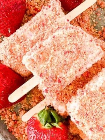 Strawberry crunch ice cream bars with fresh strawberries.