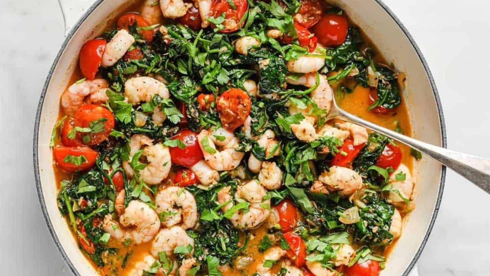 Tuscan garlic shrimp and spinach with tomatoes in a pan.