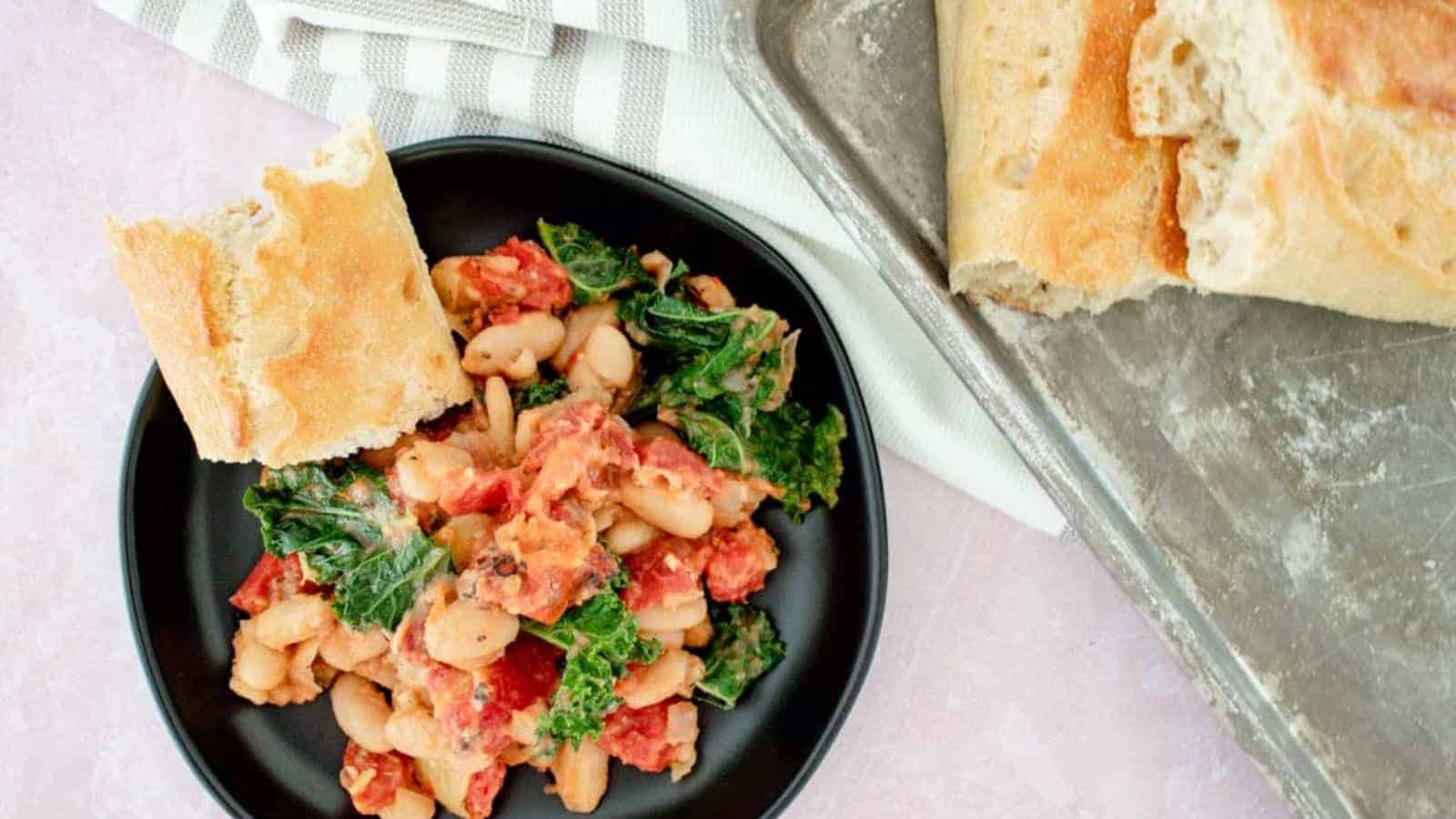 Top view of tuscan white bean skillet with kale in a black plate.