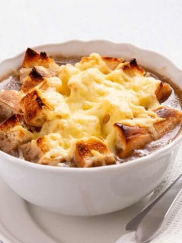 An image of vegetarian French onion soup in a bowl.