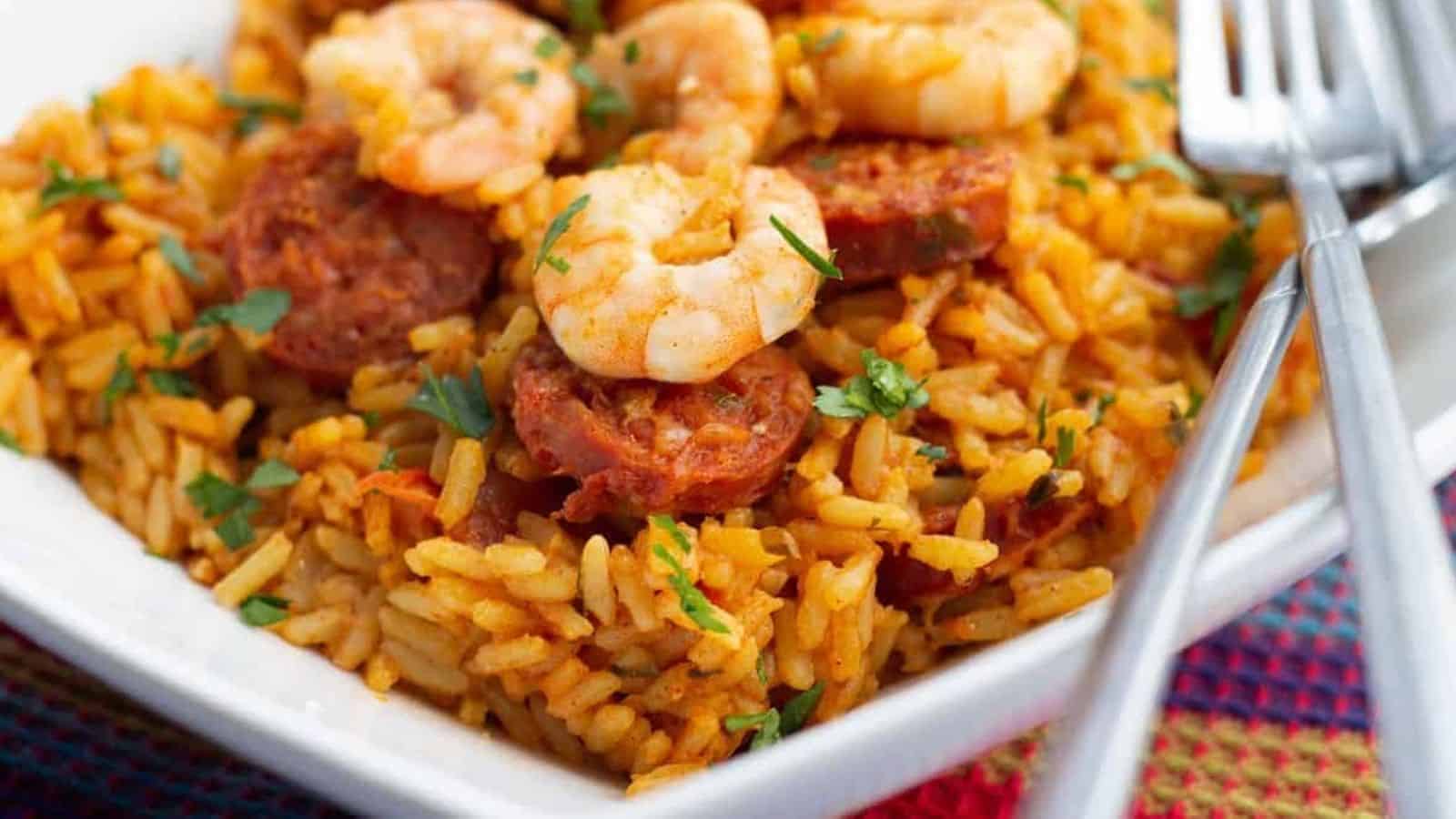 A plate of bright yellow saffron rice topped with chorizo and shrimp.