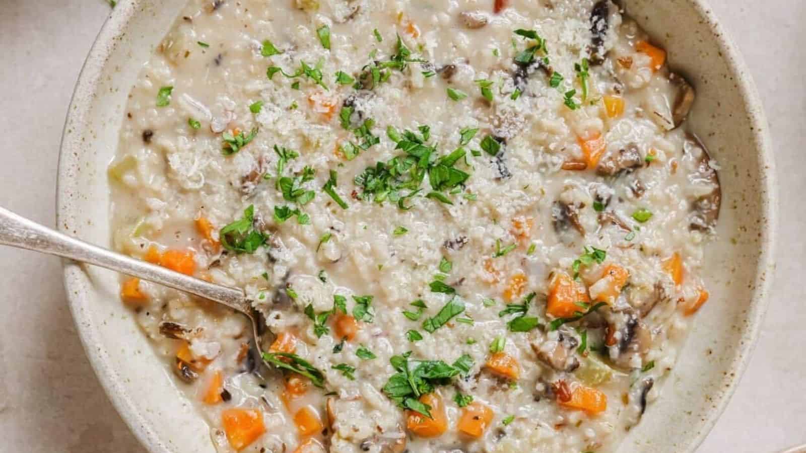 A bowl of wild rice mushroom soup with a spoon.