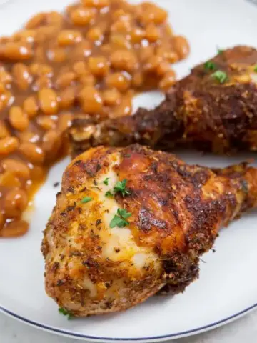 Easy Air Fryer Chicken Legs with Dry Rub on a white plate.
